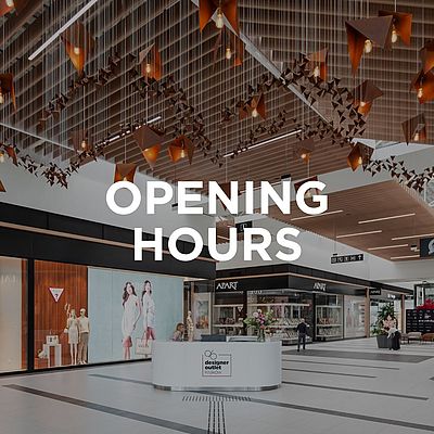 Interior of Designer Outlet Kraków with the Greenpoint store window and the text "Opening Hours" in the center of the image.