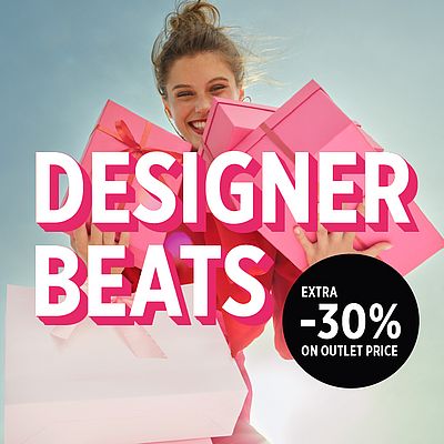 Smiling woman holding pink gifts against the sky.