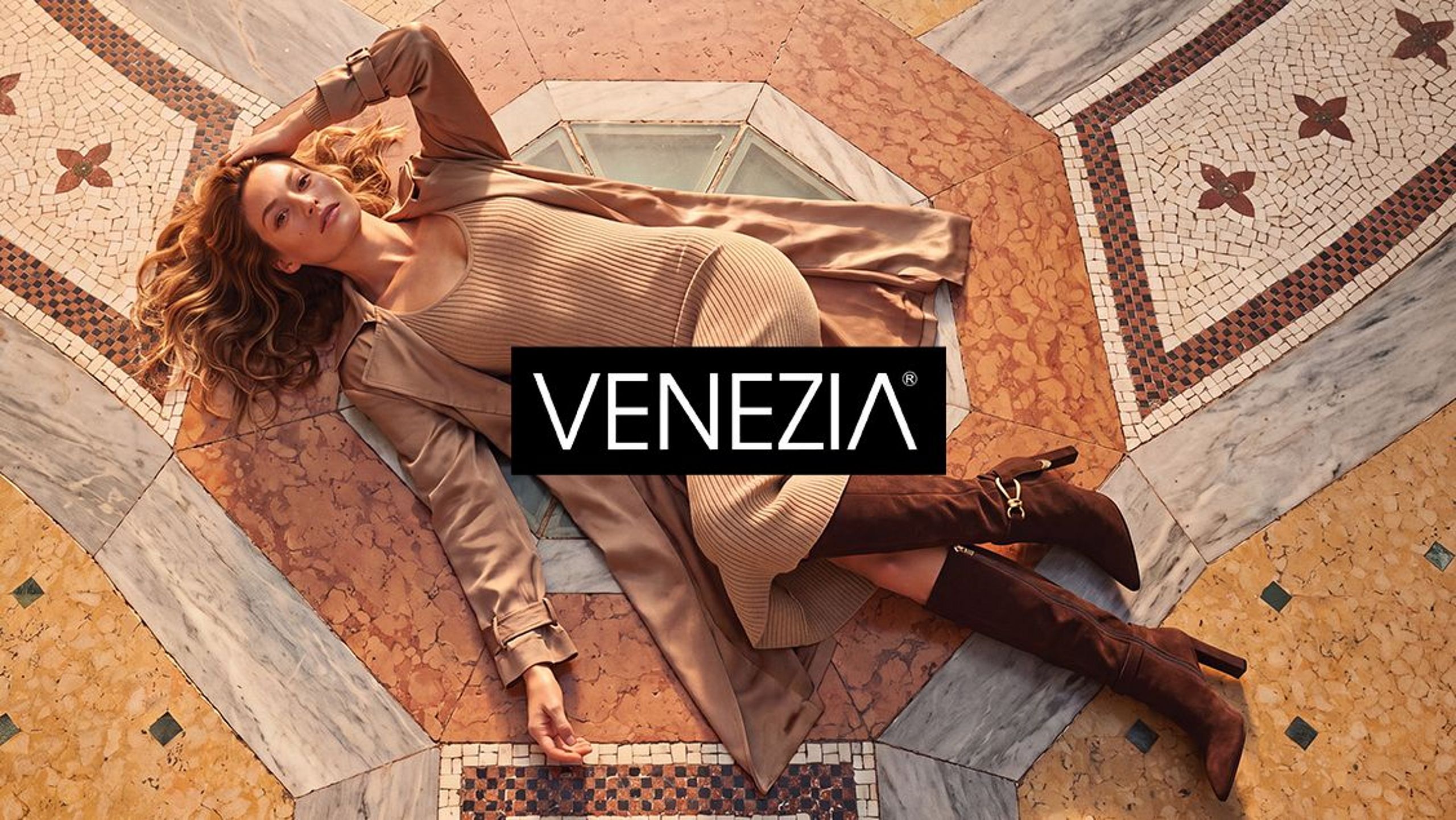 Woman in a VENEZIA outfit against a decorative mosaic.