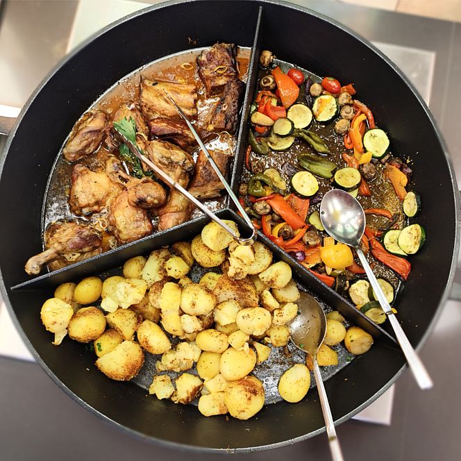 Duża patelnia podzielona na trzy części z pieczonym mięsem, grillowanymi warzywami (cukinia, papryka, pieczarki) oraz przyprawionymi ziemniakami.