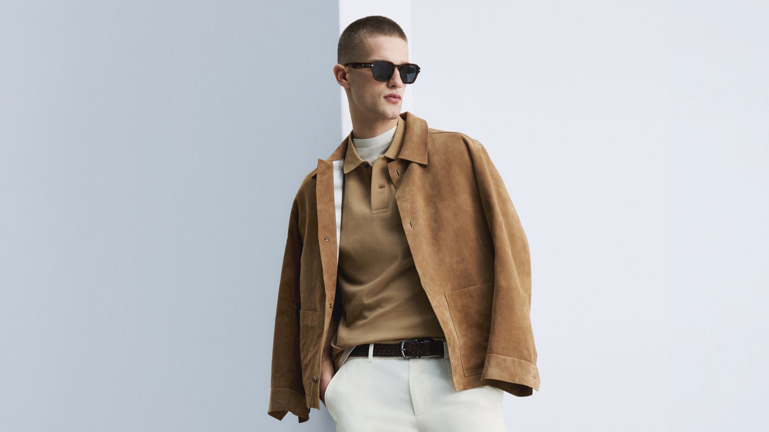 Male model wearing a brown jacket and sunglasses.