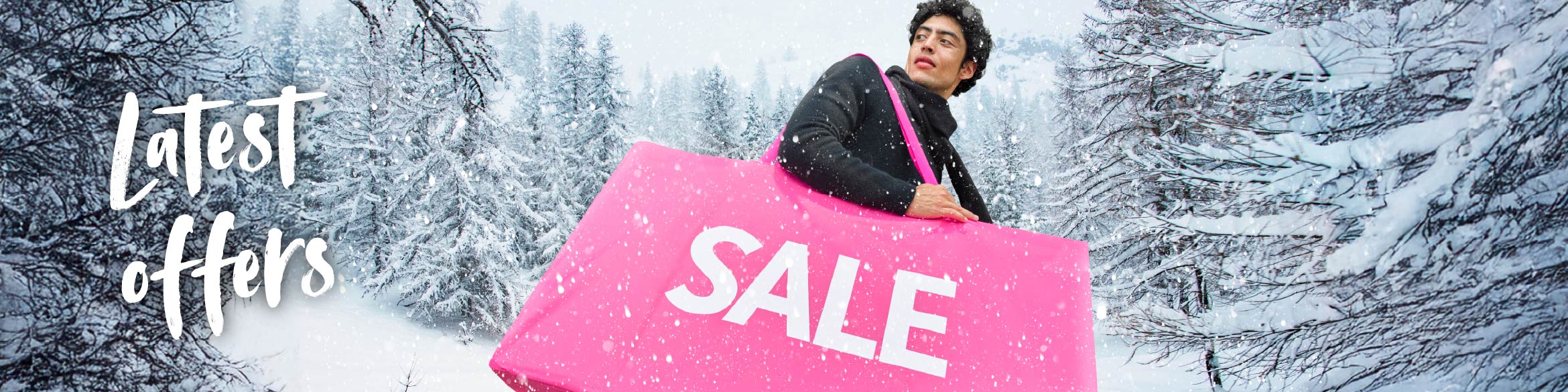 A man holding a pink bag with the word SALE, with a snowy landscape in the background.