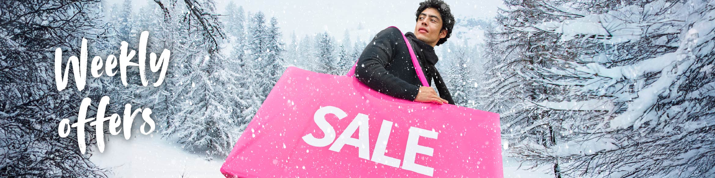 A man holding a pink bag with the word SALE, with a snowy landscape in the background.