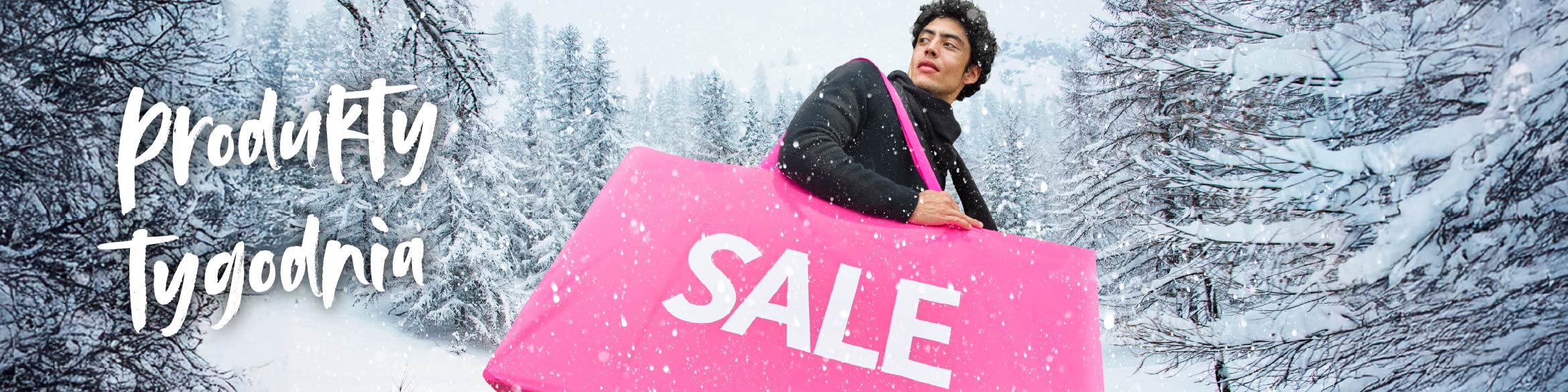 Mężczyzna trzymający różową torbę z napisem SALE, w tle zimowy krajobraz.