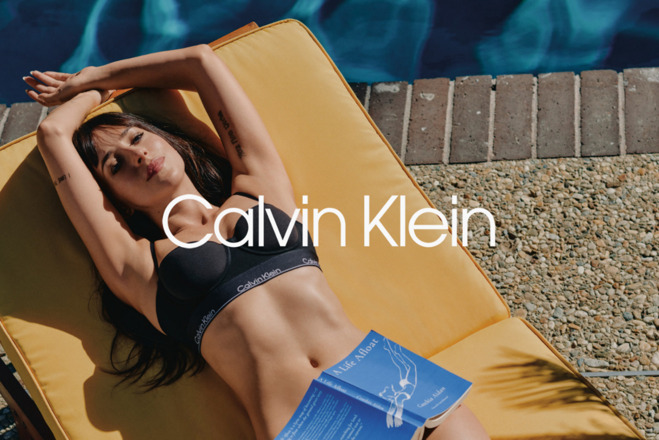 Kobieta w czarnej bieliźnie Calvin Klein odpoczywa przy basenie.