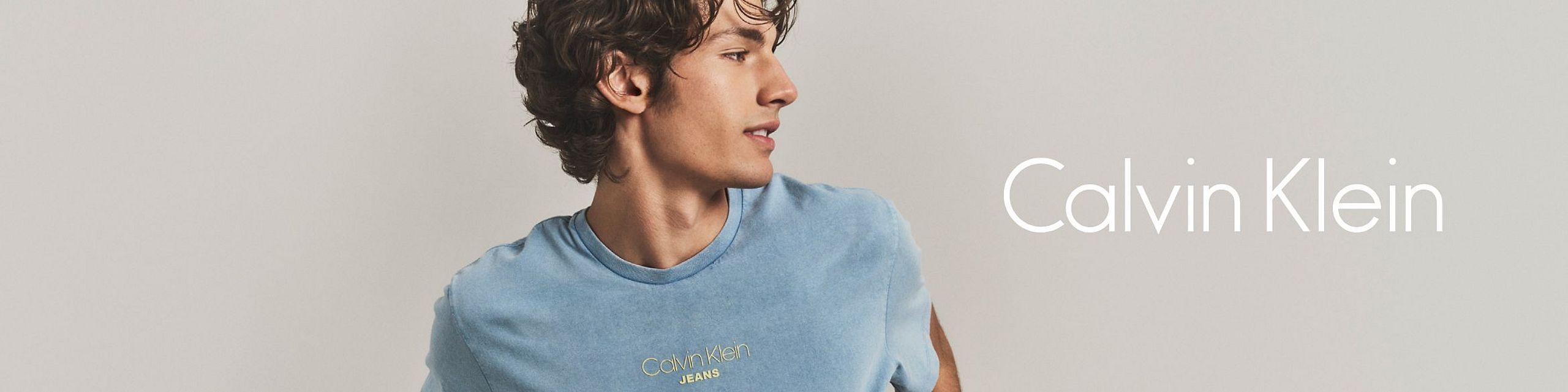 Man wearing a blue T-shirt in a Calvin Klein advertisement.