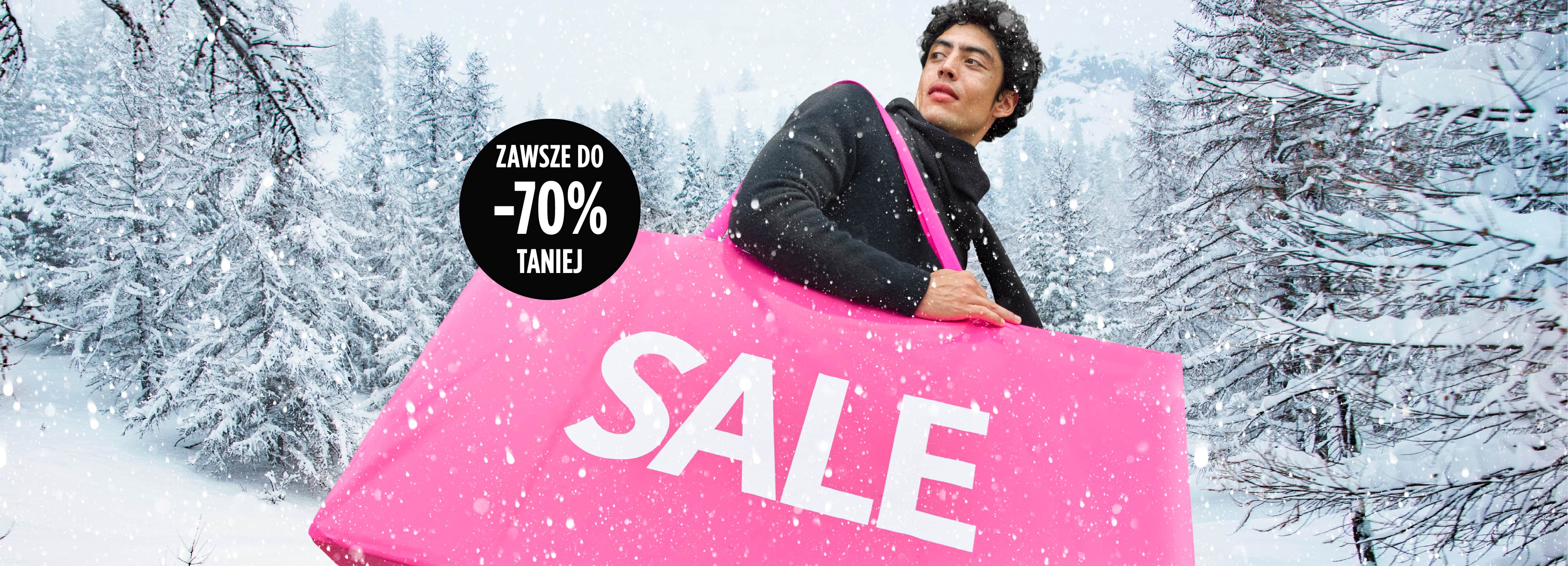 Mężczyzna trzymający różową torbę z napisem SALE, w tle zimowy krajobraz, reklama z hasłem „Zawsze do -70% taniej”.