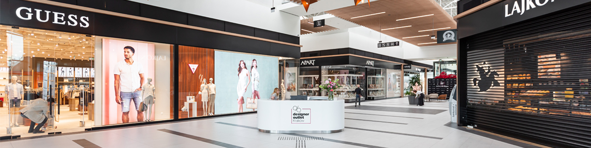 The interior of a modern shopping centre with wide aisles, shops and an information desk - a space accessible to all.